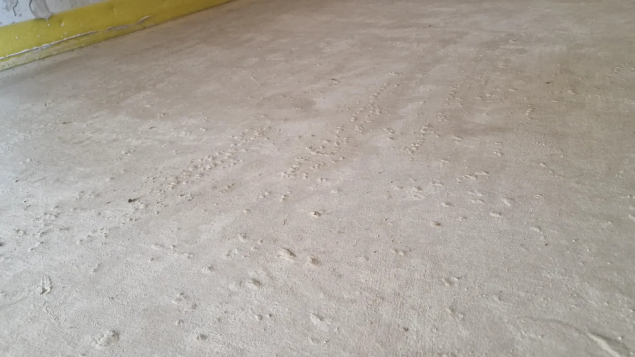 Widok zbliżonej powierzchni wylewki anhydrytowej z widocznymi drobnymi nierównościami, przygotowanej pod wykończenie podłogi