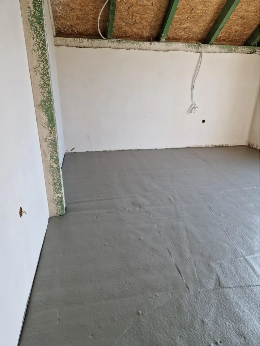 Świeżo wykonana wylewka anhydrytowa na poddaszu, gładka powierzchnia posadzki